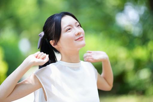 白いノースリーブワンピースの女性が空を仰ぐの写真