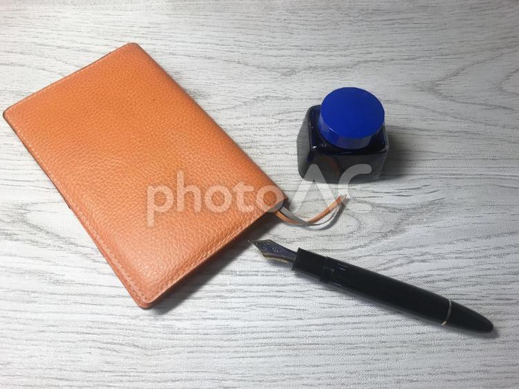 木目のテーブルに置かれた万年筆とインクと手帳 ペン,万年筆,筆記用具の写真素材