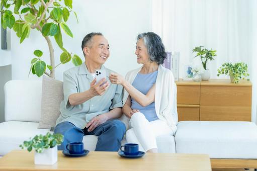 リビングでスマホを見るシニア夫婦 リビングでスマホを見るシニア夫婦 スマホ,シニア,笑顔の写真素材