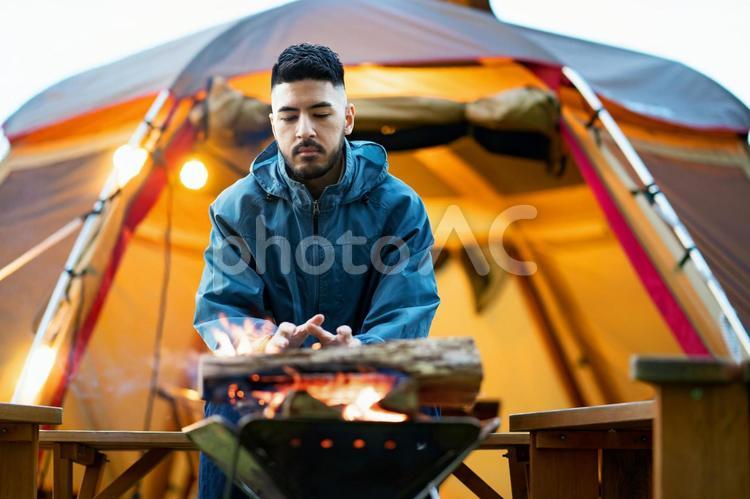 焚き火を楽しむ男性  キャンプ,ソロキャンプ,テントの写真素材