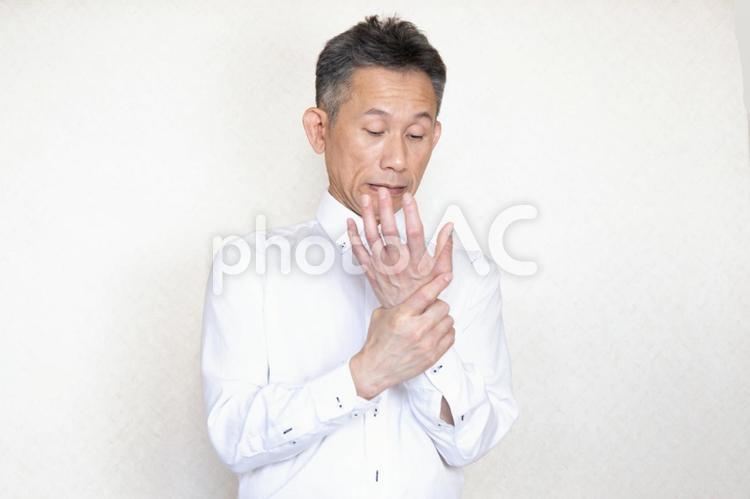 手首を押さえる中高年男性 中年,中高年,ミドルの写真素材