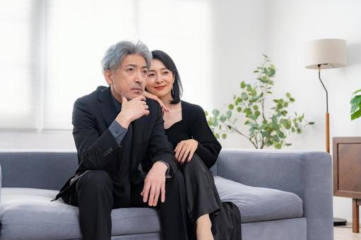 ソファに座る落ち着いた大人の男女 熟年,カップル,ミドルの写真素材