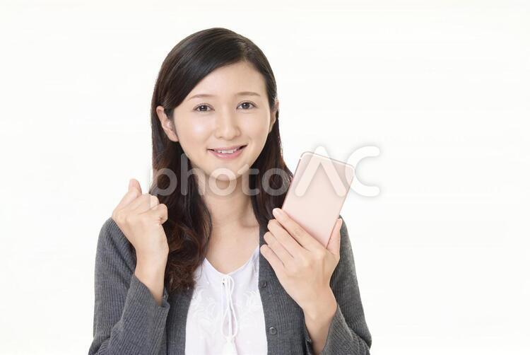 スマートフォンを持つ笑顔の女性 女性,スマートフォン,女の写真素材