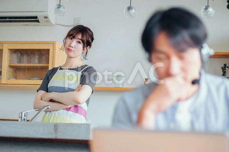 パソコンを使う男性と迷惑そうな女性 テレワーク,邪魔,パソコンの写真素材