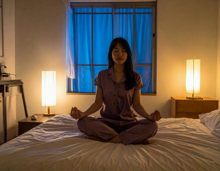 寝る前に寝室でパジャマ姿でヨガをする女性の写真