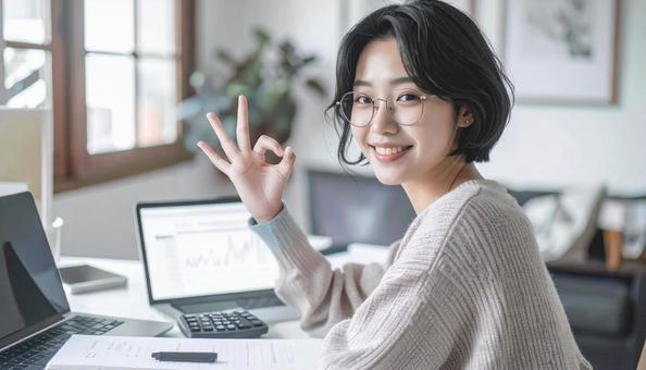 家計がうまくいきパソコンの前で微笑む女性の写真