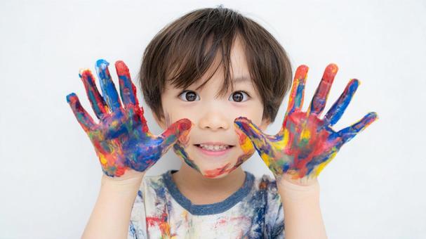 絵の具で汚れた手を見せる男の子 絵の具で汚れた手を見せる男の子の写真