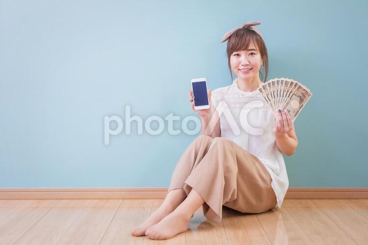 スマホとお金を持つ女性 副業,サイドビジネス,副収入の写真素材