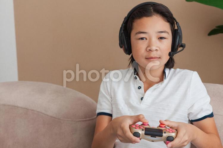 カメラ目線でゲームするヘッドフォンの男性 男性,人物,高校生の写真素材