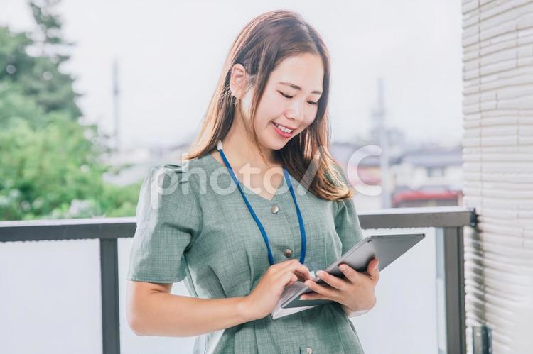 タブレットを使いながら仕事する女性 ビジネス,働く女性,タブレットの写真素材