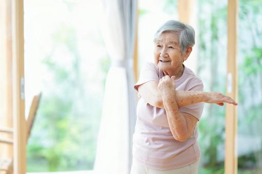 笑顔で片腕を曲げ伸ばすポーズの女性 女性,伸ばす,体操の写真素材