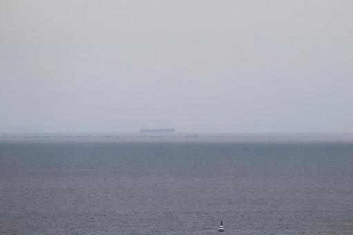 霞む空と大型タンカーと海の見える風景 霞む空と大型タンカーと海の見える風景の写真
