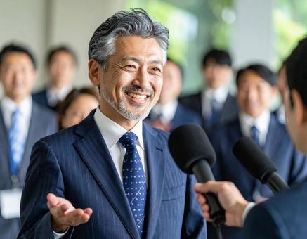 インタビューに堂々と答える笑顔の社長 インタビューに堂々と答える笑顔の社長の写真