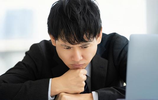 深刻な表情で考える男性ビジネスマン 深刻な表情で考える男性ビジネスマン 男性,考える,悩むの写真素材