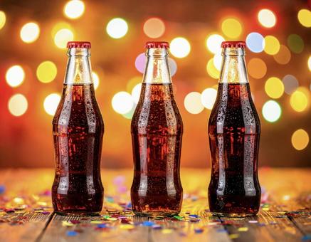 瓶入りコーラときらめく光の背景の写真
