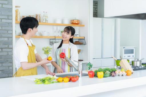 キッチンで料理を作る若い夫婦 夫婦,料理,キッチンの写真素材
