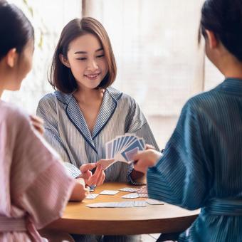 友人とトランプゲームする女性の写真