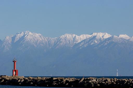 立山連峰｜海沿いの赤い灯台 雪山,海,冬の写真素材