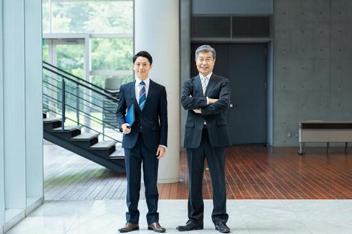オフィスの廊下に立つビジネスパーソン オフィスの廊下に立つビジネスパーソン ビジネスマン,笑顔,ビジネスパーソンの写真素材