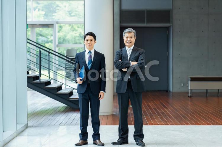オフィスの廊下に立つビジネスパーソン ビジネスマン,笑顔,ビジネスパーソンの写真素材