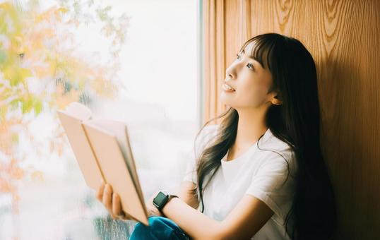 窓際で読書をする女性 窓際で読書をする女性 女性,読書,本の写真素材