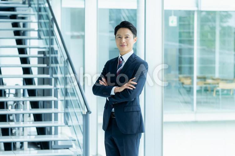 オフィスの廊下に立つビジネスマン オフィスの廊下に立つビジネスマン ビジネスマン,スーツ,オフィスの写真素材