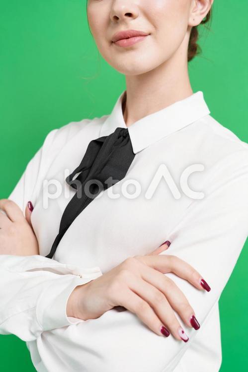 腕組みをする人の手（緑背景） 腕組み,口元,女性の写真素材