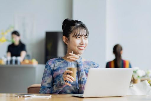 カフェで仕事をするフリーランスの若い女性 カフェで仕事をするフリーランスの若い女性の写真