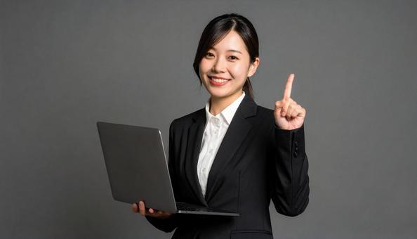笑顔で指を立てるビジネスウーマンの写真
