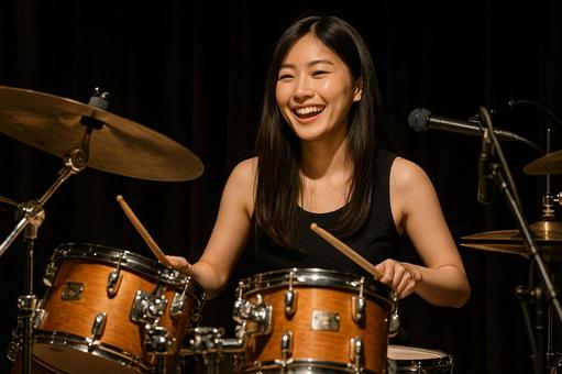 ライブで楽しそうにドラムを叩く日本人女性 ライブで楽しそうにドラムを叩く日本人女性の写真