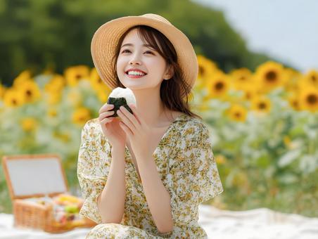 ひまわり園でランチのおにぎりを食べる女性 ひまわり園でランチのおにぎりを食べる女性の写真