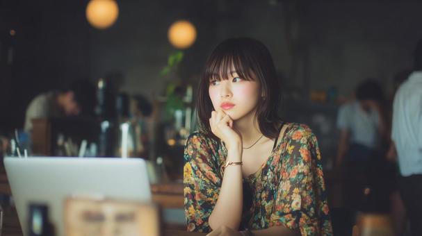 カフェでノートパソコンを使用する女性の写真