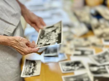 写真を持つ高齢女性の手元とたくさんの写真 写真を持つ高齢女性の手元とたくさんの写真 写真,プリント,たくさんの写真素材