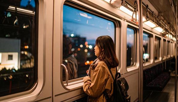 夜、電車内から外を見る日本人女性 夜、電車内から外を見る日本人女性の写真