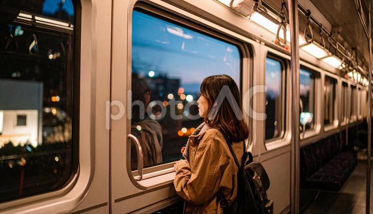 夜、電車内から外を見る日本人女性 車窓,電車,女性の写真素材