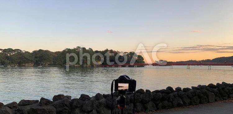 夕焼けに染まる海を撮影しているカメラ 海,夕焼け,カメラの写真素材