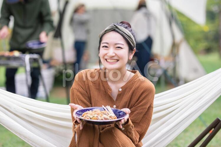 キャンプでたこ焼きを食べる女性 キャンプ,食べる,女性の写真素材