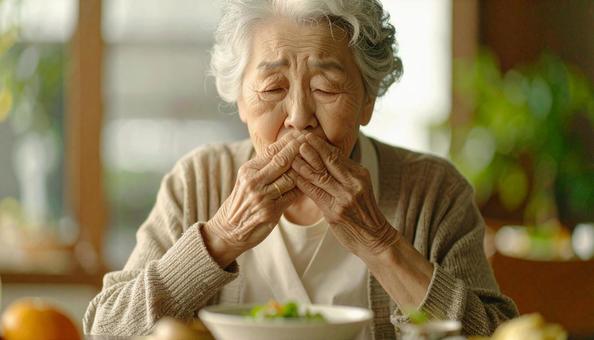 食事中、歯が痛む高齢者女性 食事中、歯が痛む高齢者女性の写真