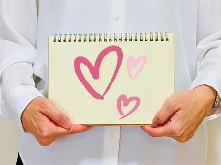 ハートマークの絵を持った女性 ハートマークの絵を持った女性 ハート,女性,愛情の写真素材