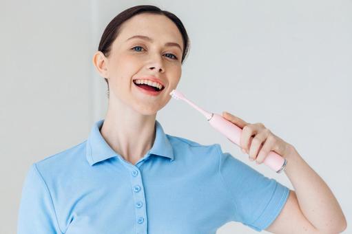 これから電動歯ブラシをする女性 これから電動歯ブラシをする女性の写真