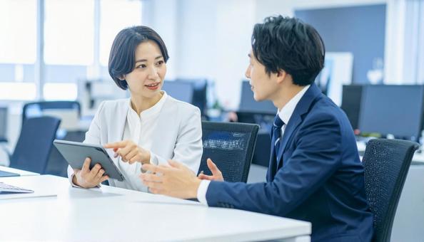 タブレットで打ち合わせするビジネス社員 タブレットで打ち合わせするビジネス社員の写真