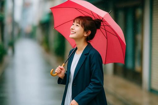 傘をさして歩く笑顔の女性 傘をさして歩く笑顔の女性の写真