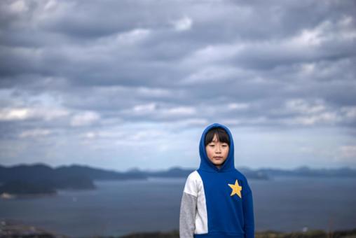 <素材>秋の天気が悪い日に山へ登った少年 <素材>秋の天気が悪い日に山へ登った少年の写真