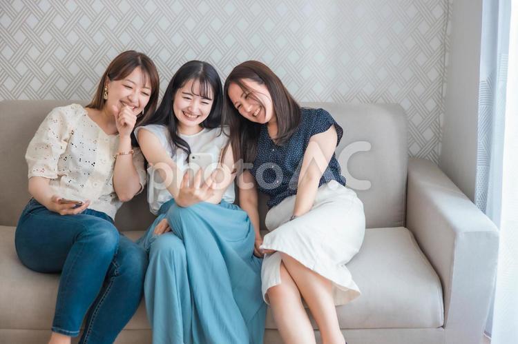 スマホを使う女性たち（爆笑・自撮り） スマートフォン,スマホ,女子会の写真素材