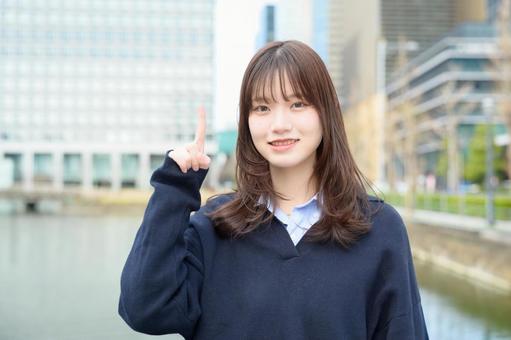 ビル街で指をさす女子高生 高校生,女子高生,指さしの写真素材