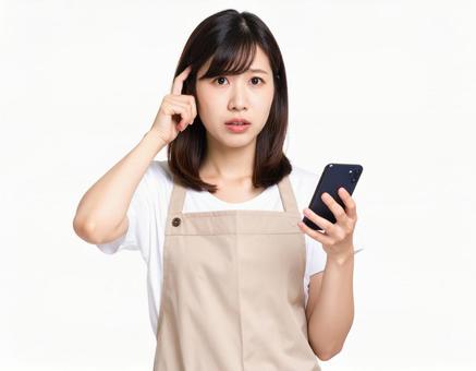 スマホを持ち考える主婦 スマホを持ち考える主婦の写真