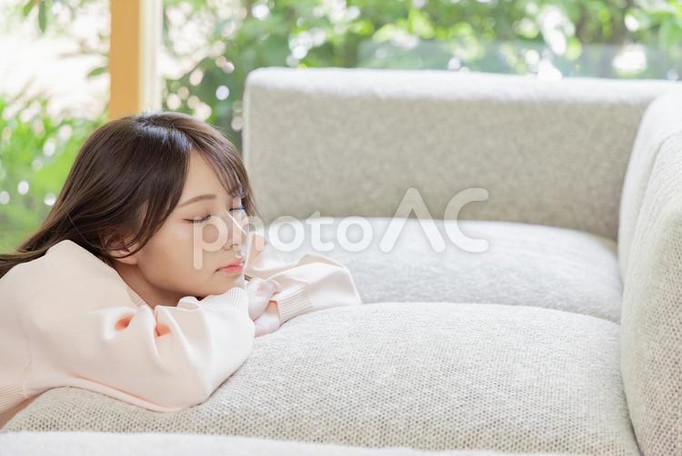 ソファにもたれる可愛い女性 女性,リビング,見上げるの写真素材