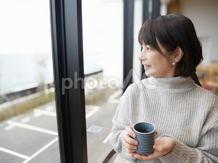 お茶を持って微笑む女性 コーヒー,茶,カップの写真素材