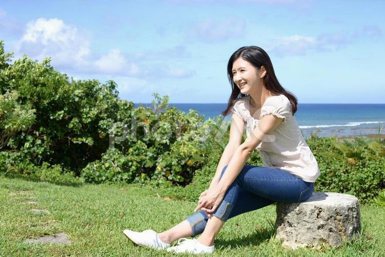沖縄の美しい海辺でくつろぐ女性 日本,沖縄,海の写真素材