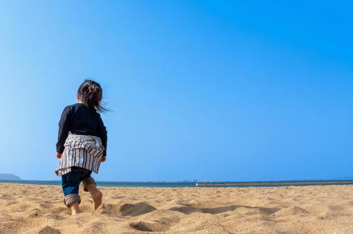 砂浜を歩く子供の後ろ姿 砂浜を歩く子供の後ろ姿 子供,夏の海,少女の写真素材